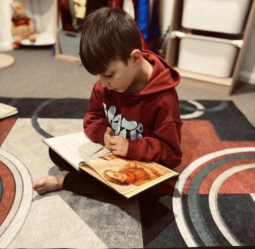 Adult reading a storybook with a child