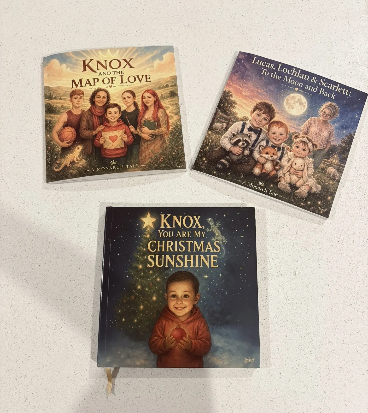 Three finished Monarch Tales books photographed together